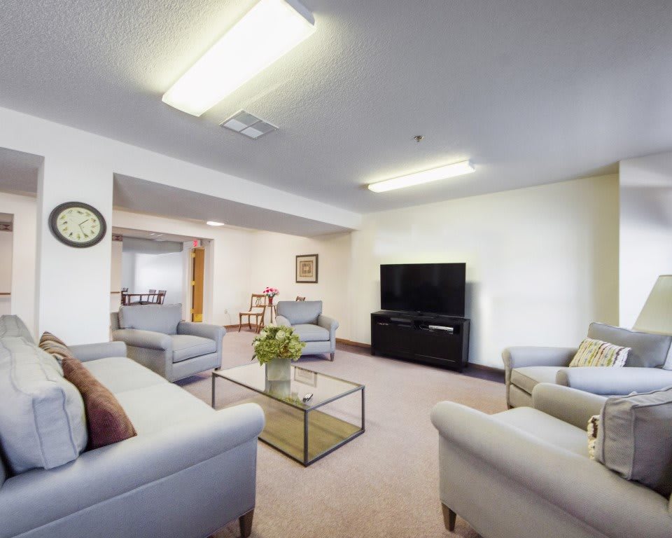 A modern living room with comfortable sofas, a large television, and a glass coffee table.