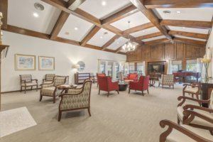 A spacious and bright living area with comfortable seating and wooden ceiling beams.