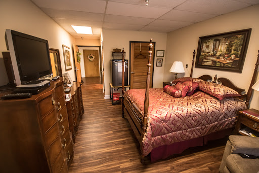 A cozy bedroom featuring a wooden bed, decorative artwork, and warm lighting.