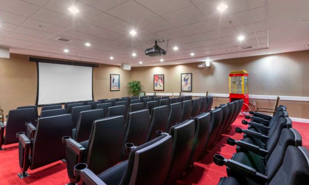 A well-arranged theater room with rows of comfortable seating facing a large screen.