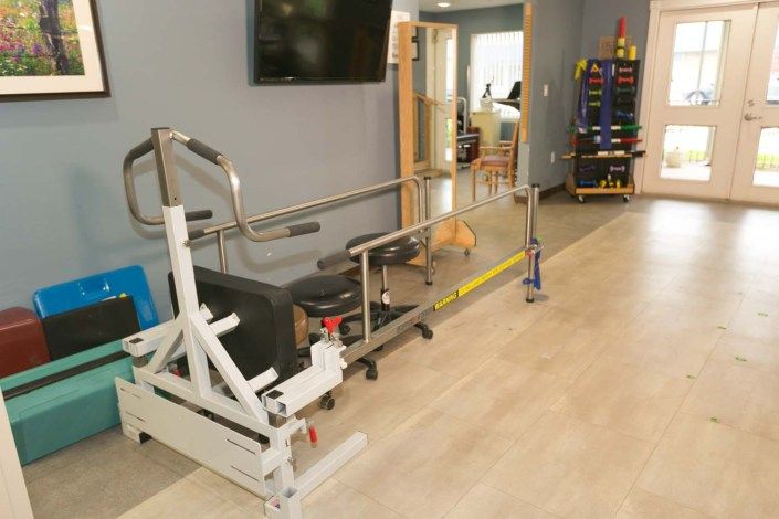A physical therapy room equipped with parallel bars and exercise equipment.