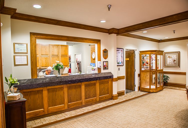 A welcoming hotel reception area with wood paneling and warm lighting.