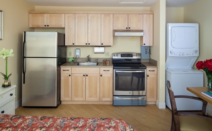 A modern kitchen with stainless steel appliances and wooden cabinets.