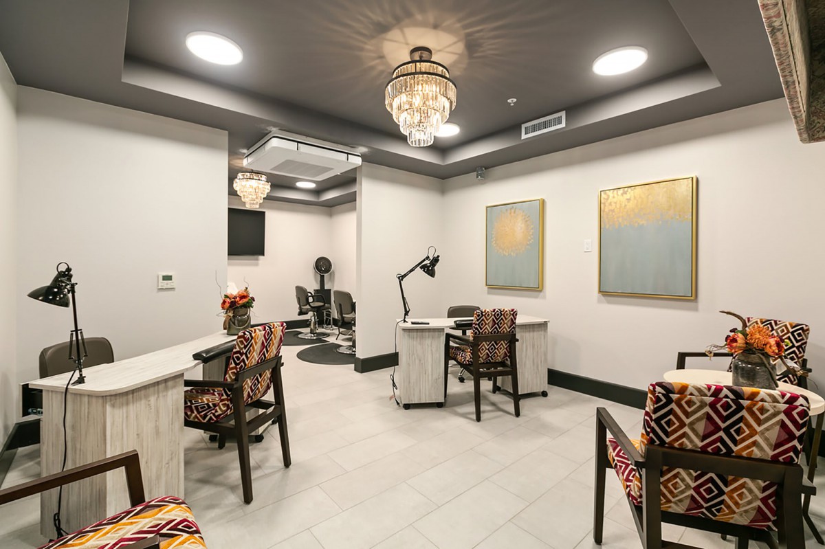 A modern nail salon interior with decorative chandeliers and colorful artwork.
