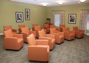 A meeting room with multiple orange chairs arranged in rows.