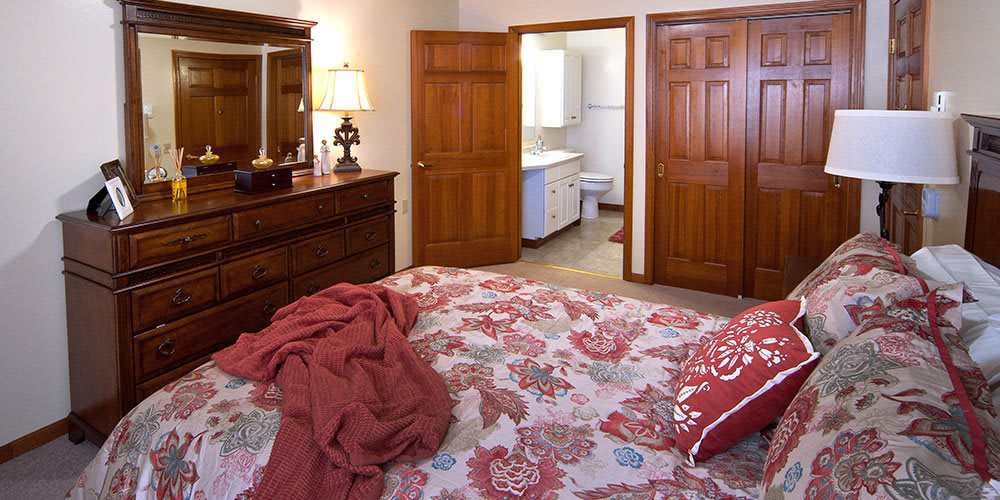 A cozy bedroom with floral bedding and wooden furniture.