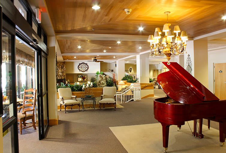 Elegant hotel lobby with a grand piano and chandelier.