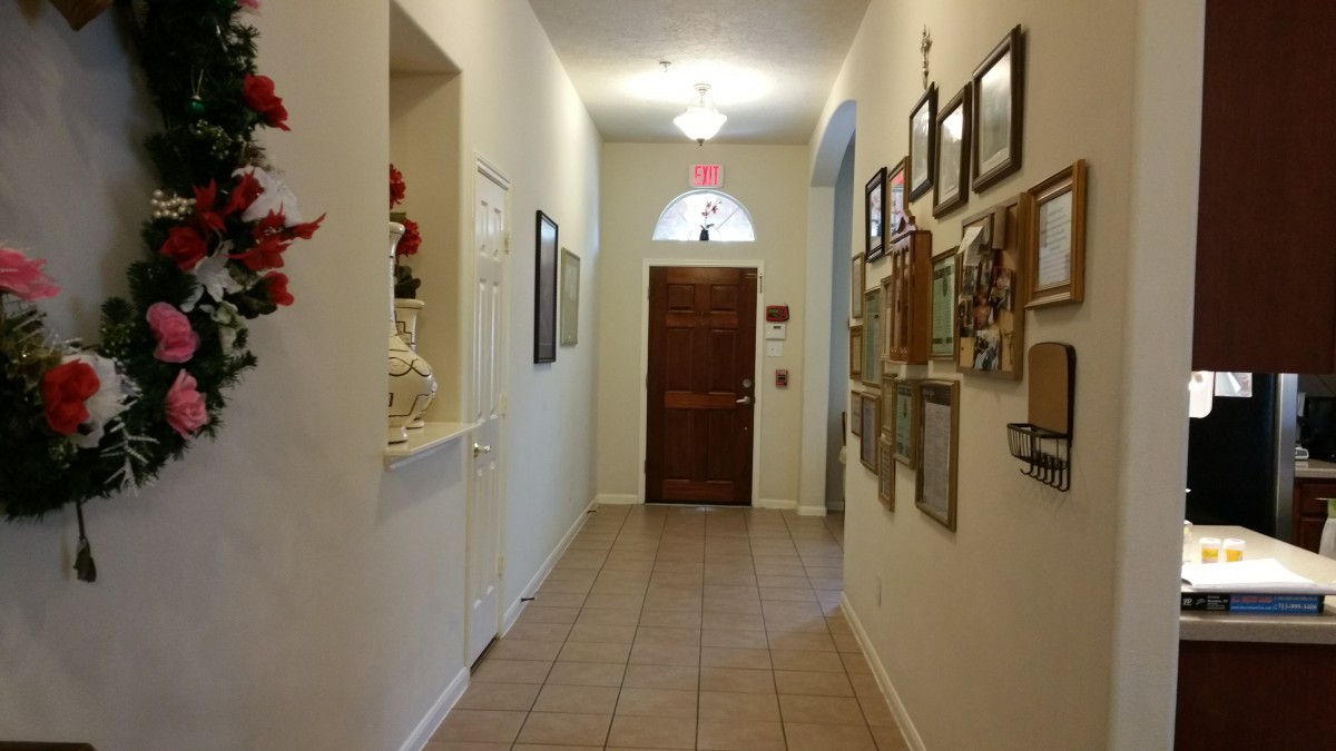 A well-decorated hallway with pictures on the wall leading to a wooden door.