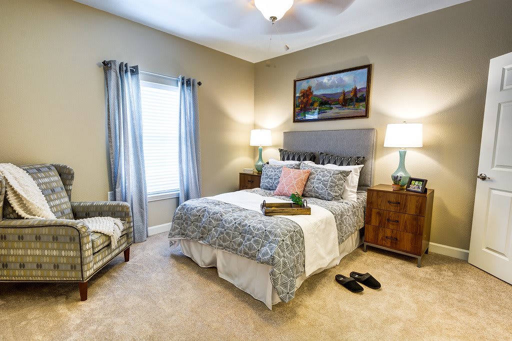 A cozy bedroom with a neatly made bed, elegant decor, and soft lighting.