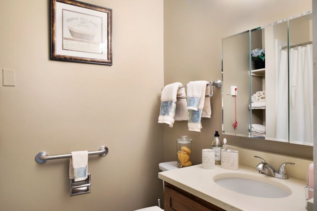 A neatly organized bathroom with towels, toiletries, and a mirror.