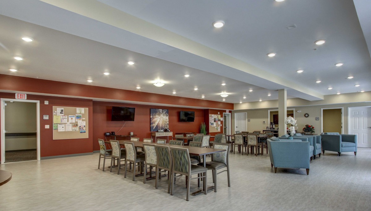 A modern dining area with neatly arranged tables and chairs, featuring bright lighting and a warm ambiance.