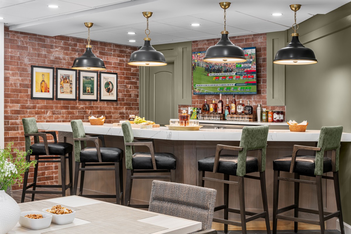 A modern home bar with a brick wall, stylish pendant lights, and comfortable seating.