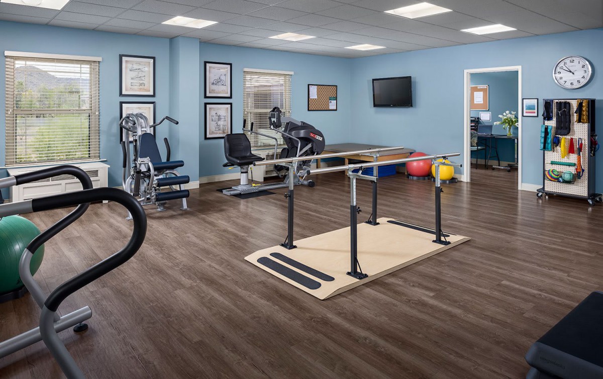 A well-equipped physical therapy room featuring various exercise machines and rehabilitation tools.