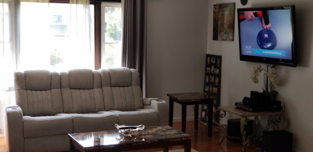 A cozy living room with a sofa, coffee table, and artwork on the walls.