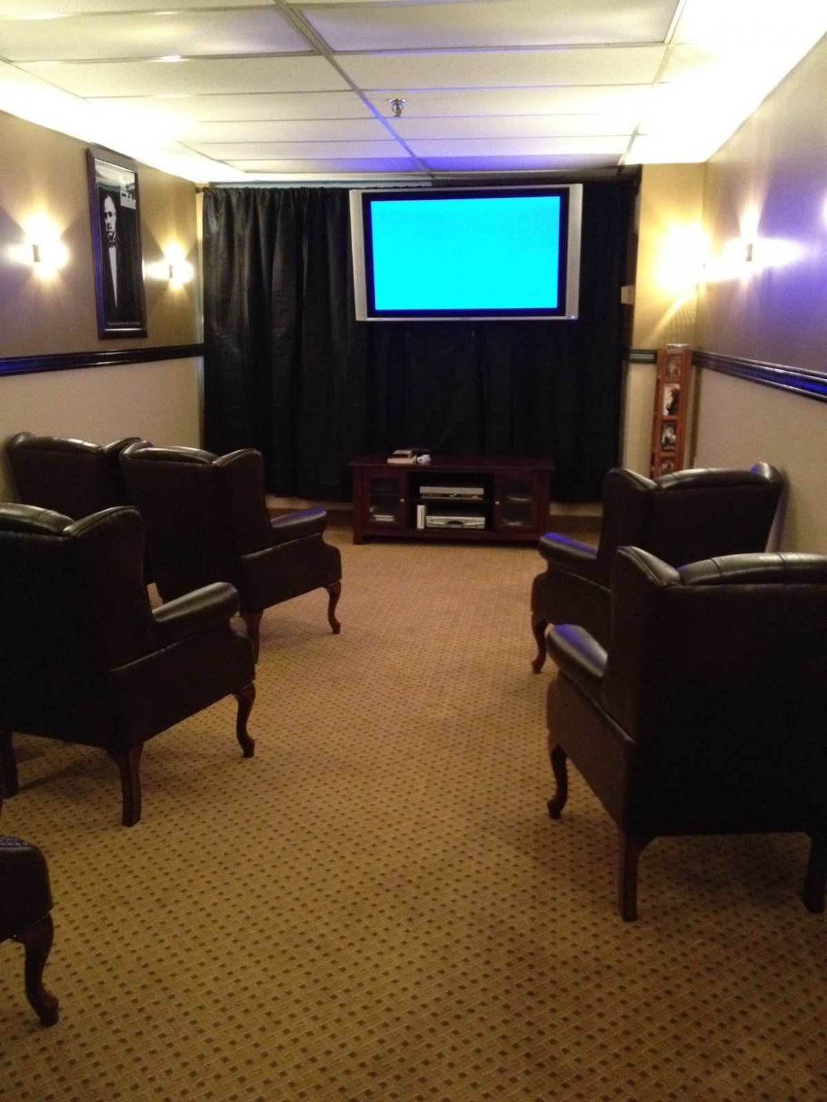 A cozy home theater room with comfortable chairs facing a large screen.