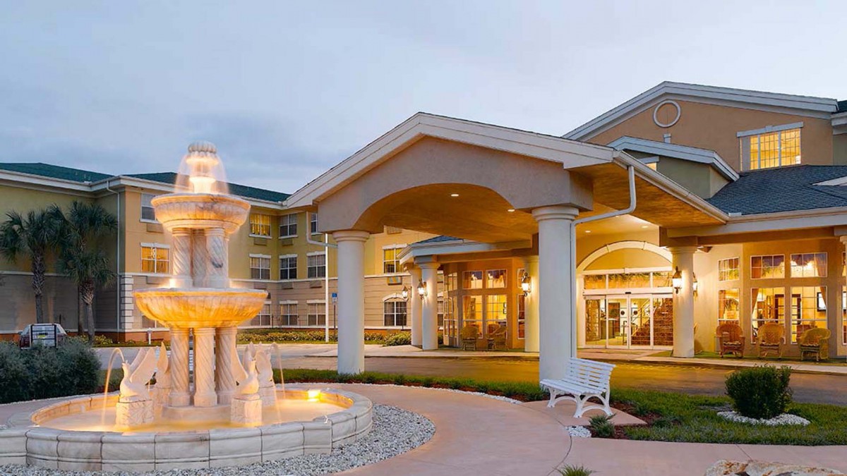 A hotel entrance featuring an elegant fountain and covered driveway.