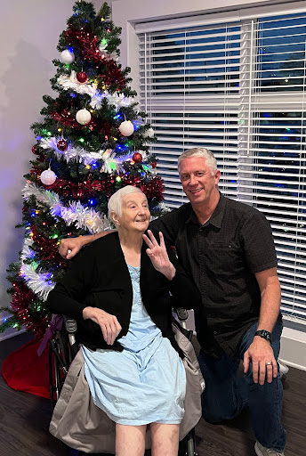 A joyful moment shared between family members in front of a beautifully decorated Christmas tree.