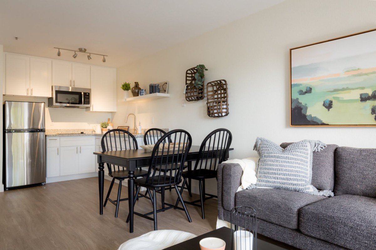 A modern open-concept living space featuring a cozy dining area and a stylish kitchen.