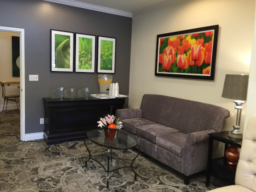 A cozy and modern living room featuring a comfortable sofa, decorative artwork, and a glass coffee table.