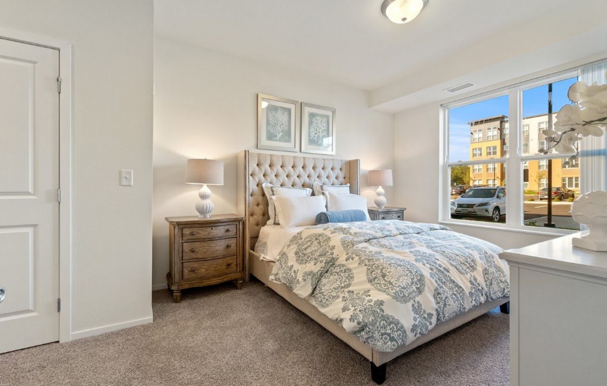 A cozy bedroom with elegant decor and a large window.