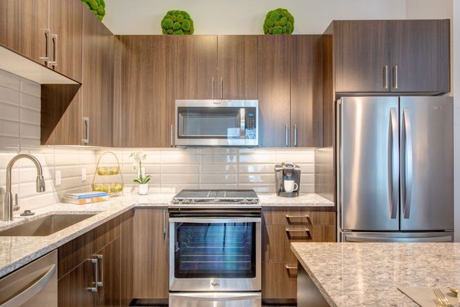 A modern kitchen with wood cabinets and stainless steel appliances.