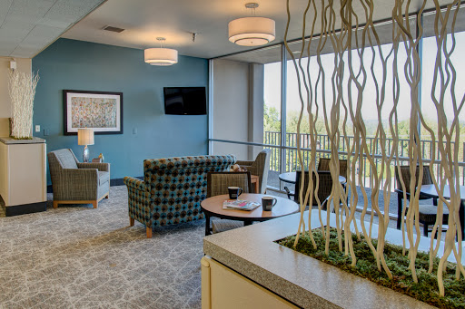 A modern lounge area designed for comfort and relaxation, featuring blue walls and stylish furniture.