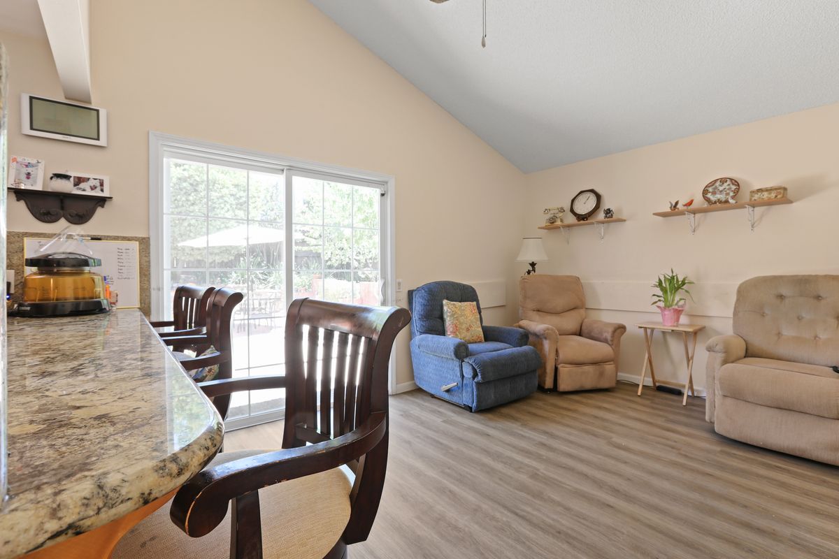 A cozy living room with comfortable seating and a view of the outdoors through a sliding glass door.