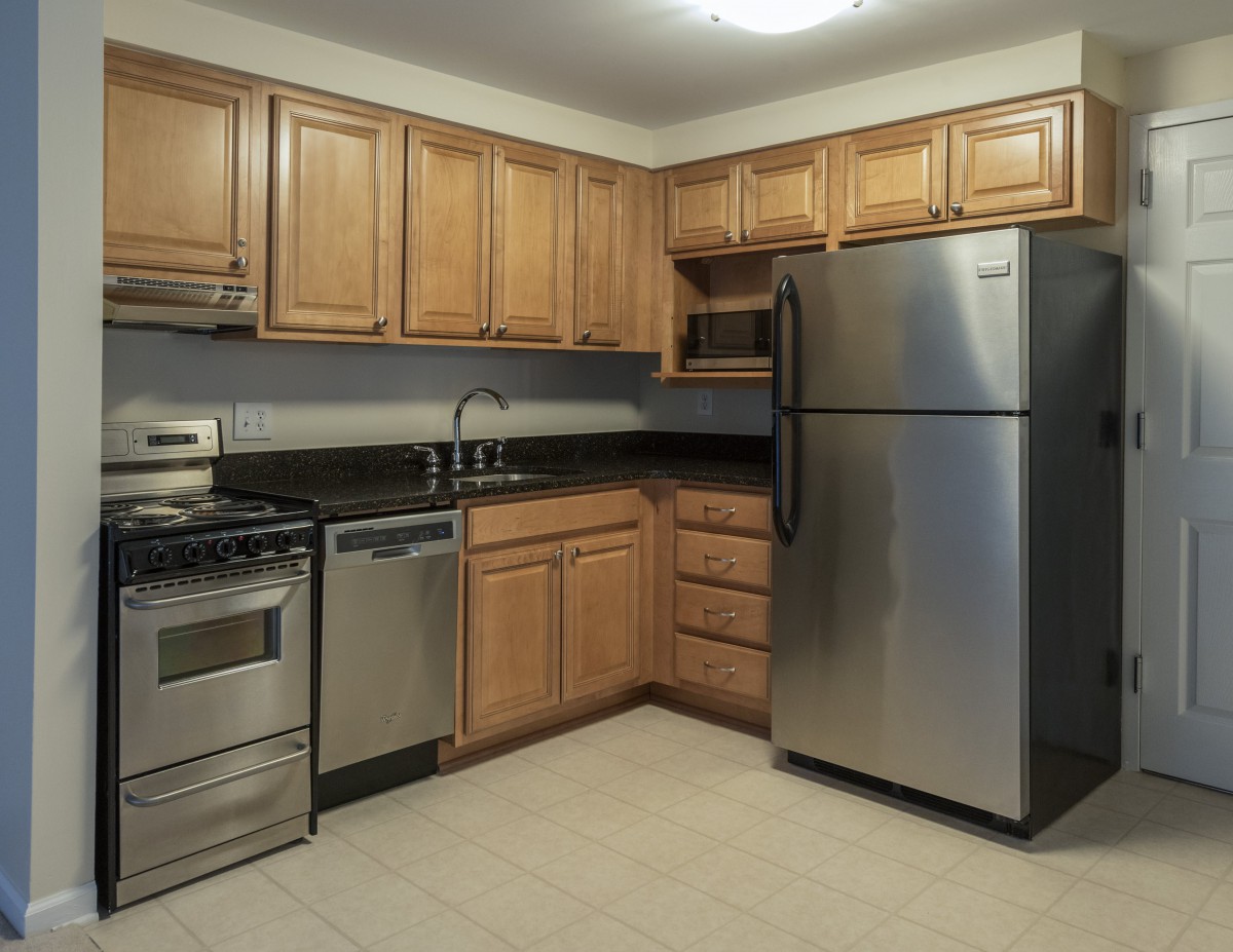 A modern kitchen with stainless steel appliances and wooden cabinets.
