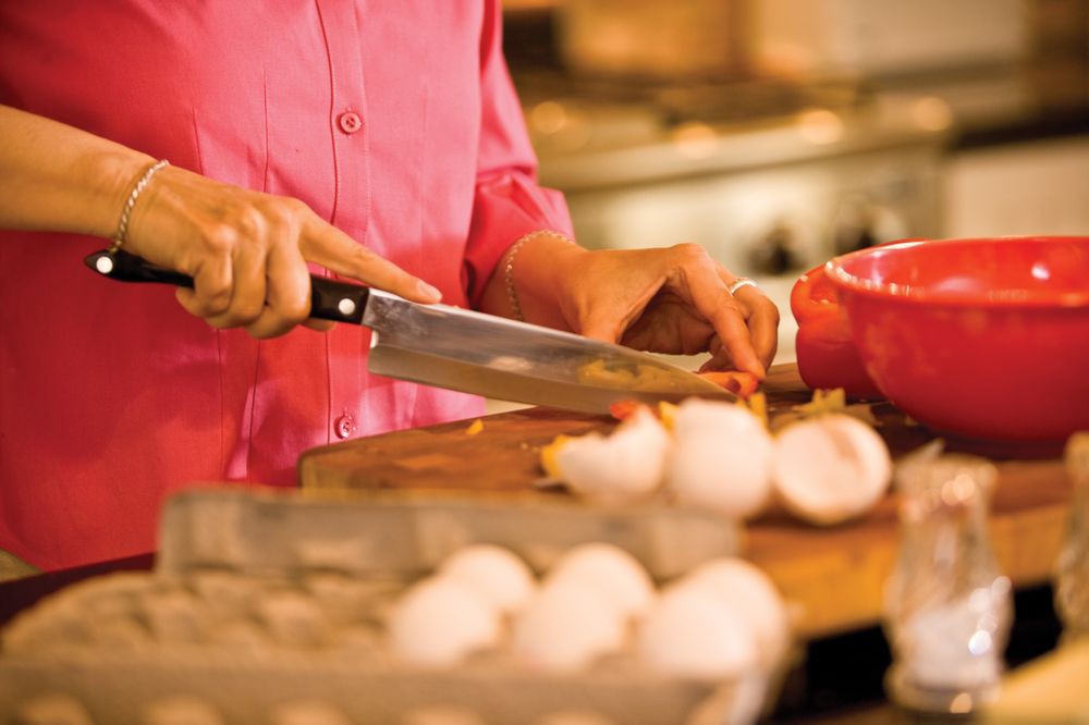 A person chopping vegetables in the kitchen.