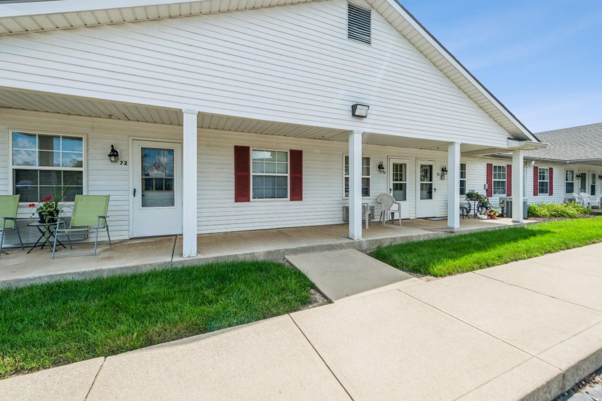 A suburban home with a front porch and a well-kept lawn.