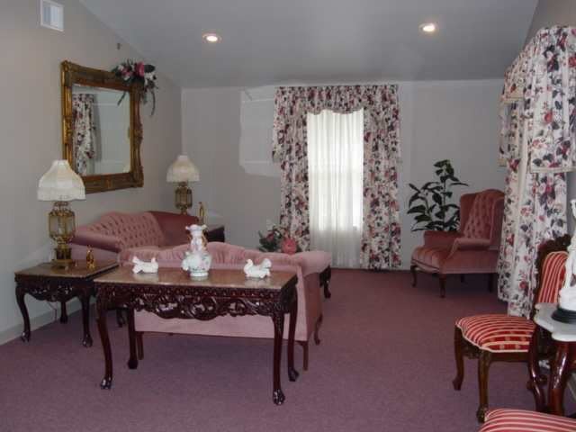 A vintage-style living room with pink furniture and floral accents.