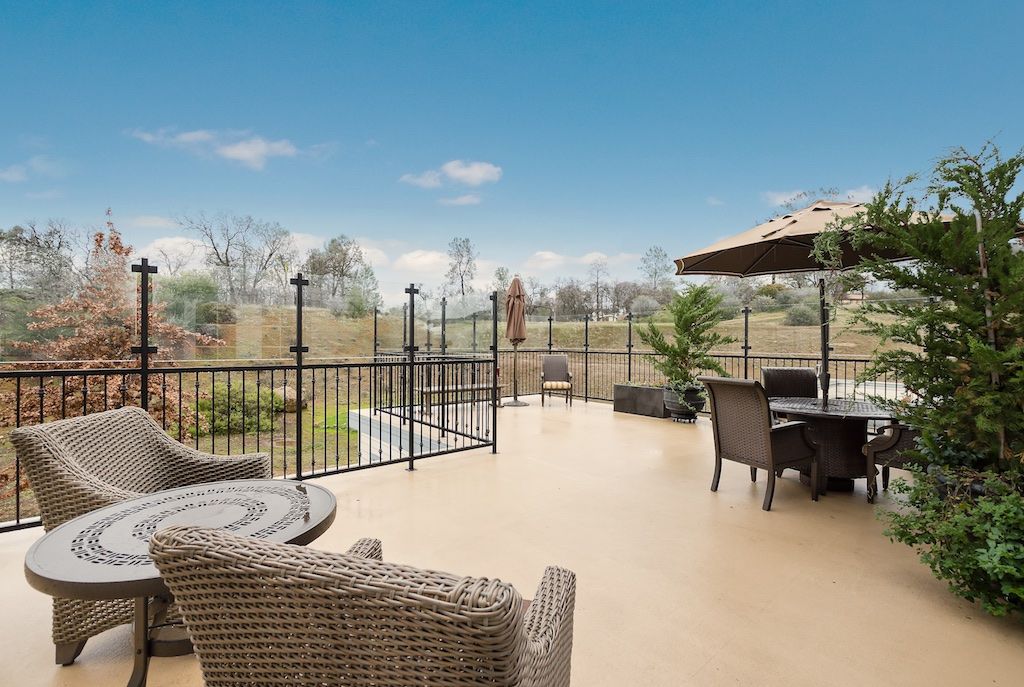 A spacious patio with wicker furniture and a scenic landscape view.
