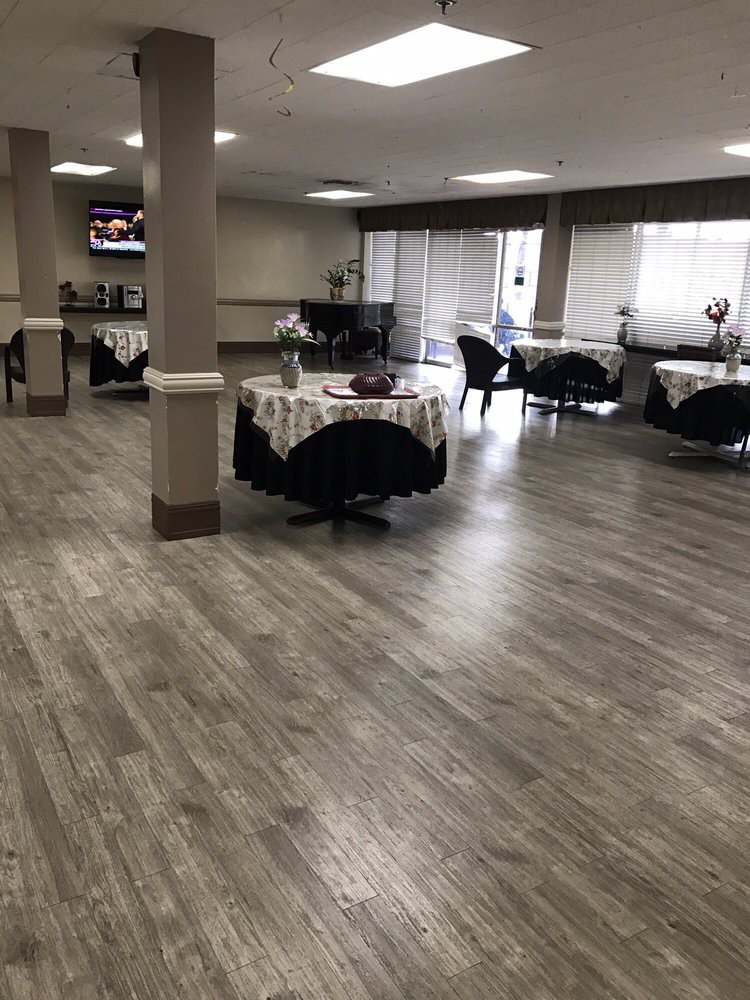 A spacious dining area with round tables and wooden flooring.