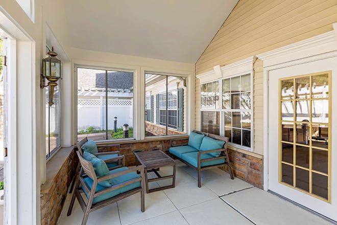 A cozy patio with outdoor seating and large windows.