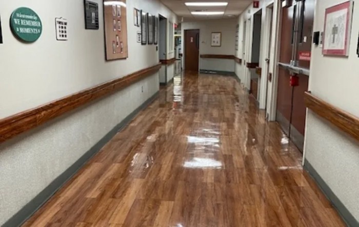 A hospital hallway with a shiny, polished floor.