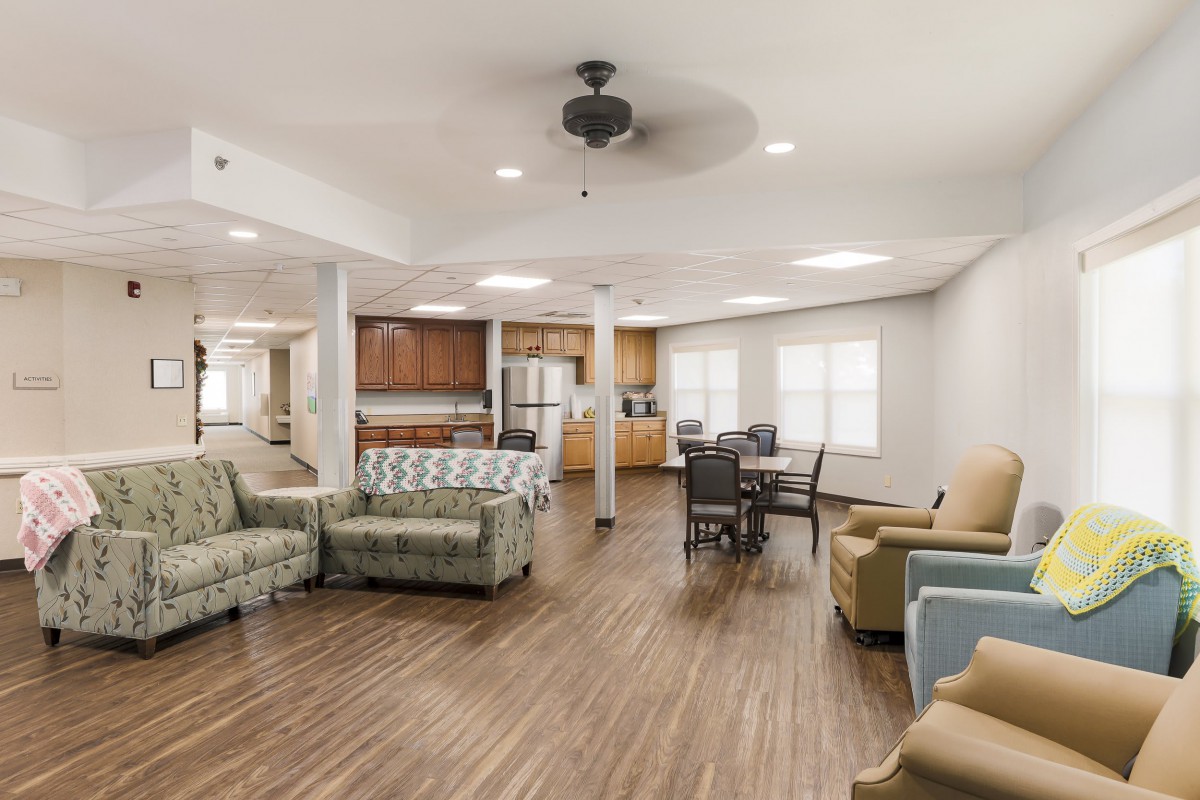 A spacious living area featuring an open floor plan with a kitchen and comfortable seating.