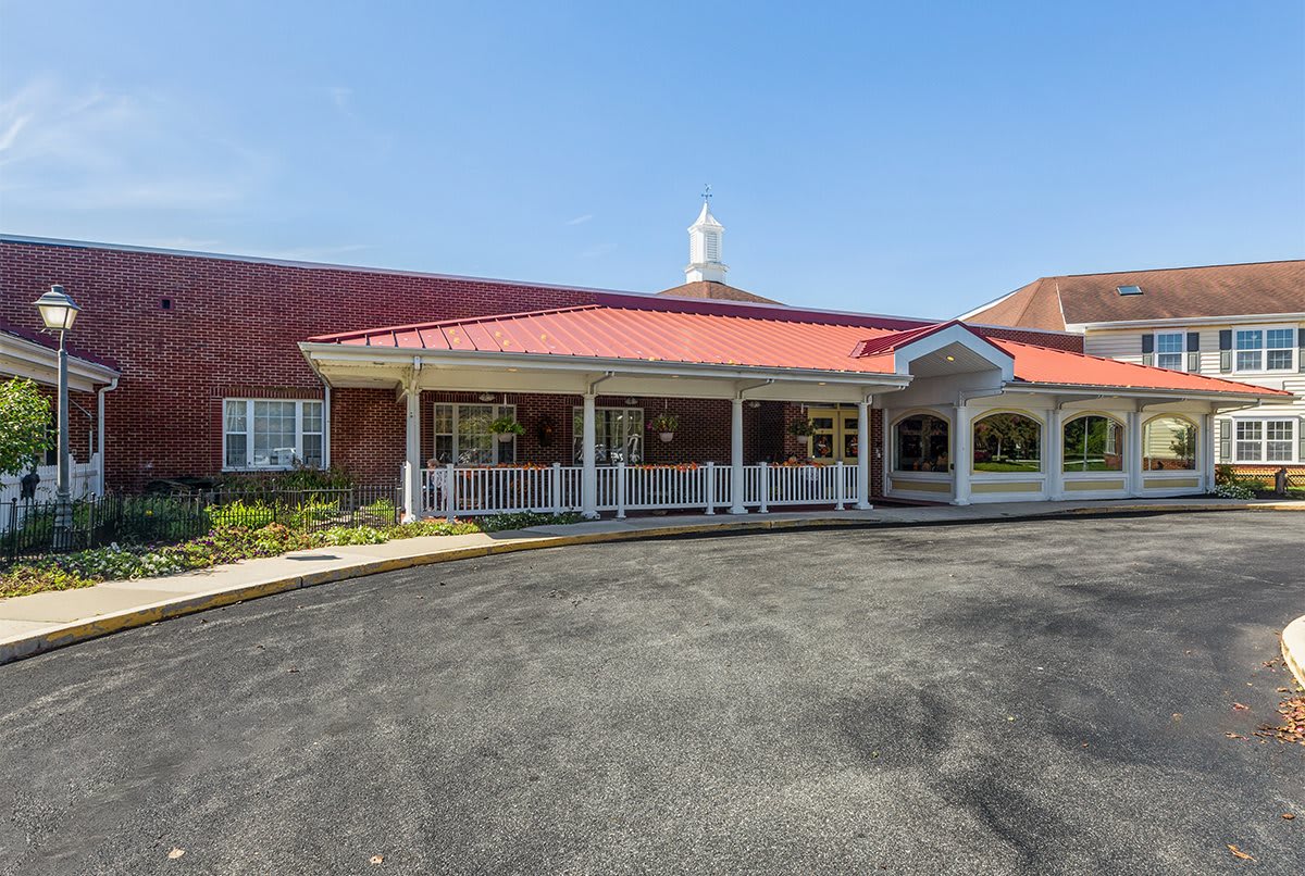 A building with a red roof and a driveway leading to its entrance.