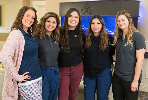 Group of women smiling indoors in casual attire.