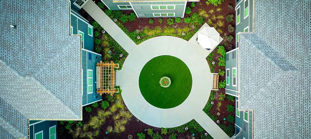 Aerial view of a landscaped area featuring circular pathways and greenery.