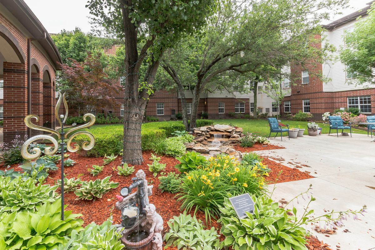 A beautifully landscaped garden with lush greenery and a peaceful seating area.