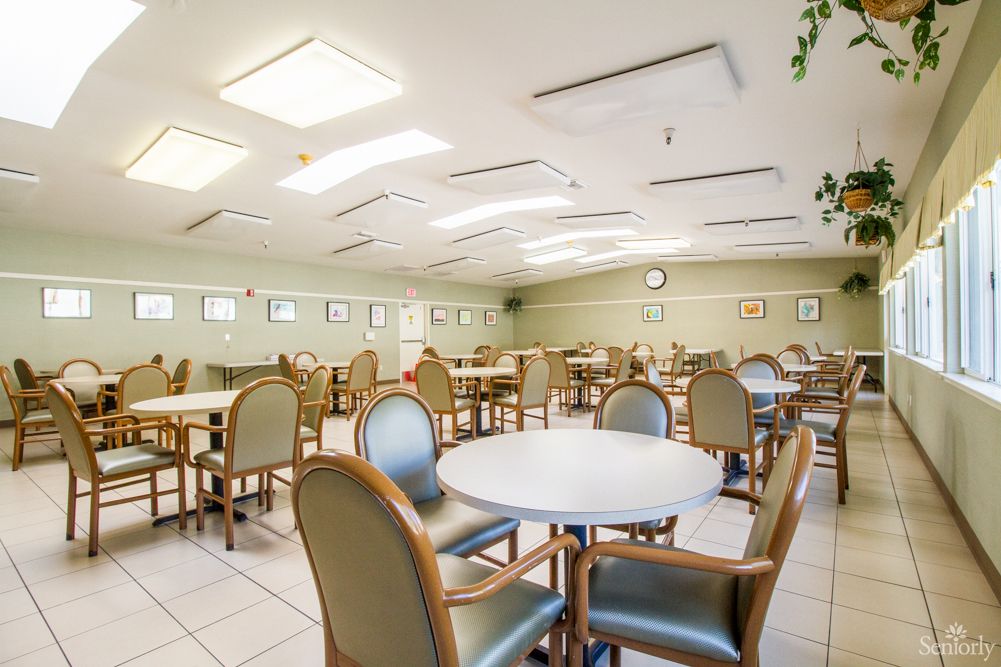 A spacious and well-lit empty dining room with multiple tables and chairs.