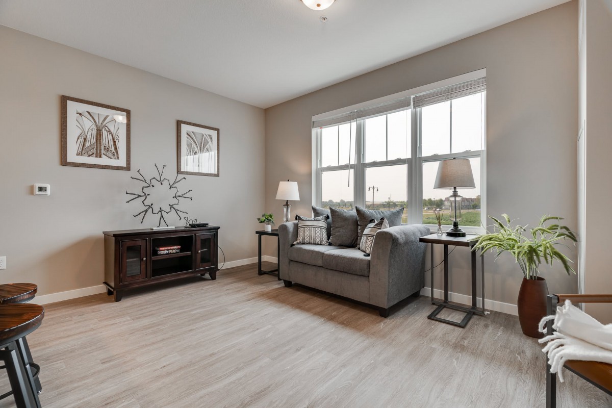 A cozy living room with a comfortable couch, tasteful decor, and ample natural light streaming through the large window.