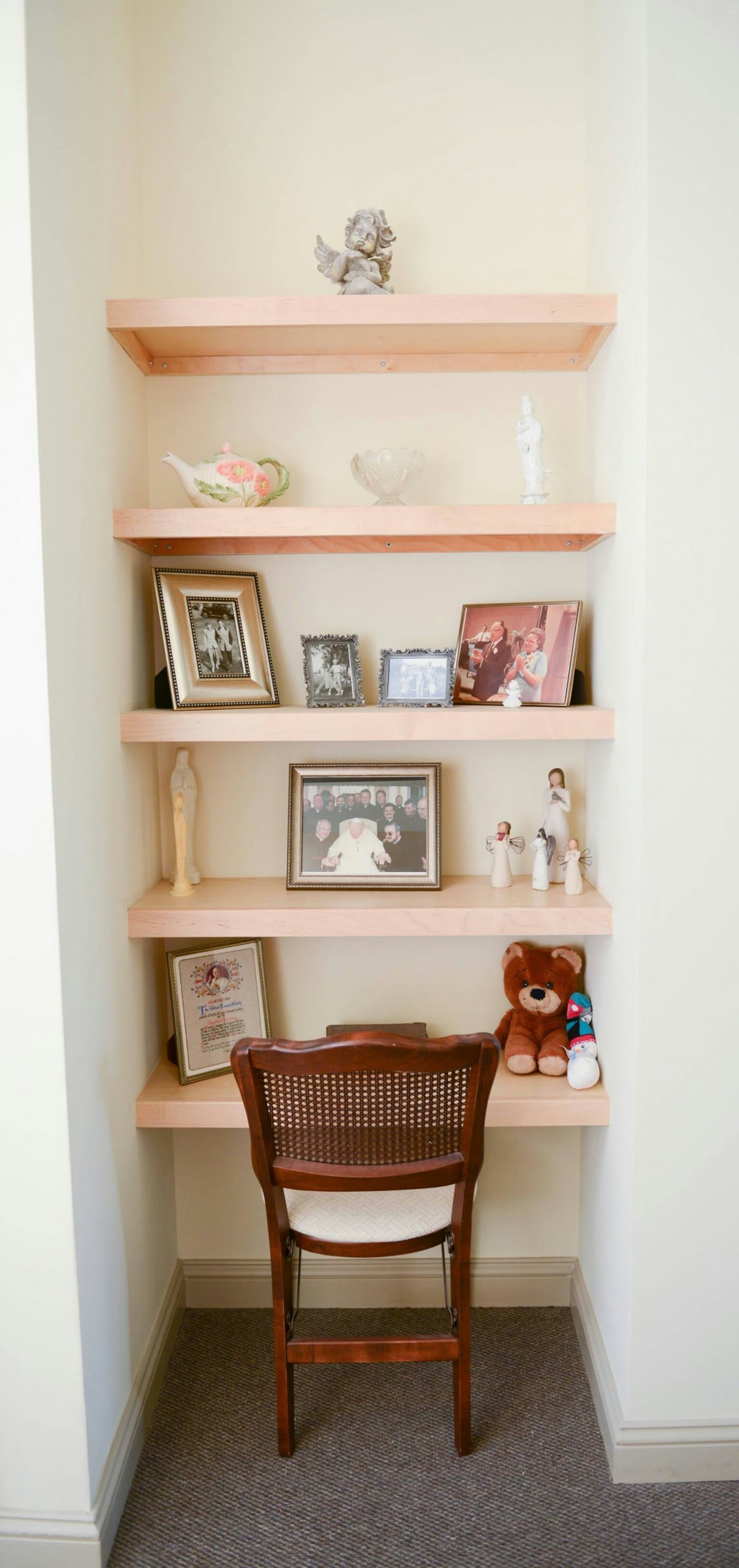 A neatly arranged shelf displaying framed photographs and small decorative items, adding a personal touch to the room's interior.