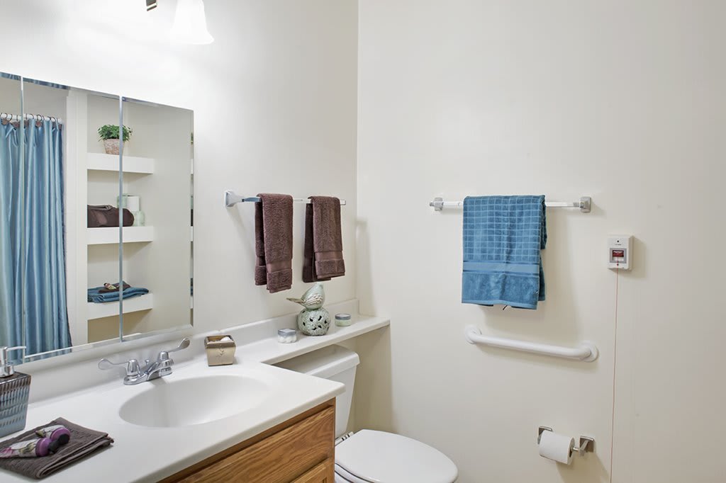 A neatly arranged bathroom with towels and a mirror above the sink.