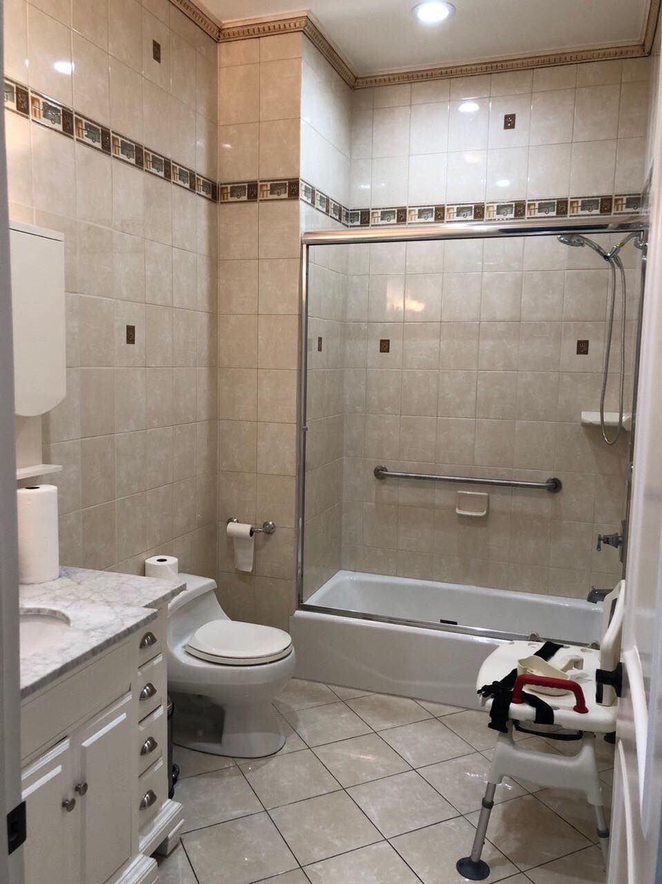 A clean and modern bathroom with a tiled floor, bathtub, and shower.