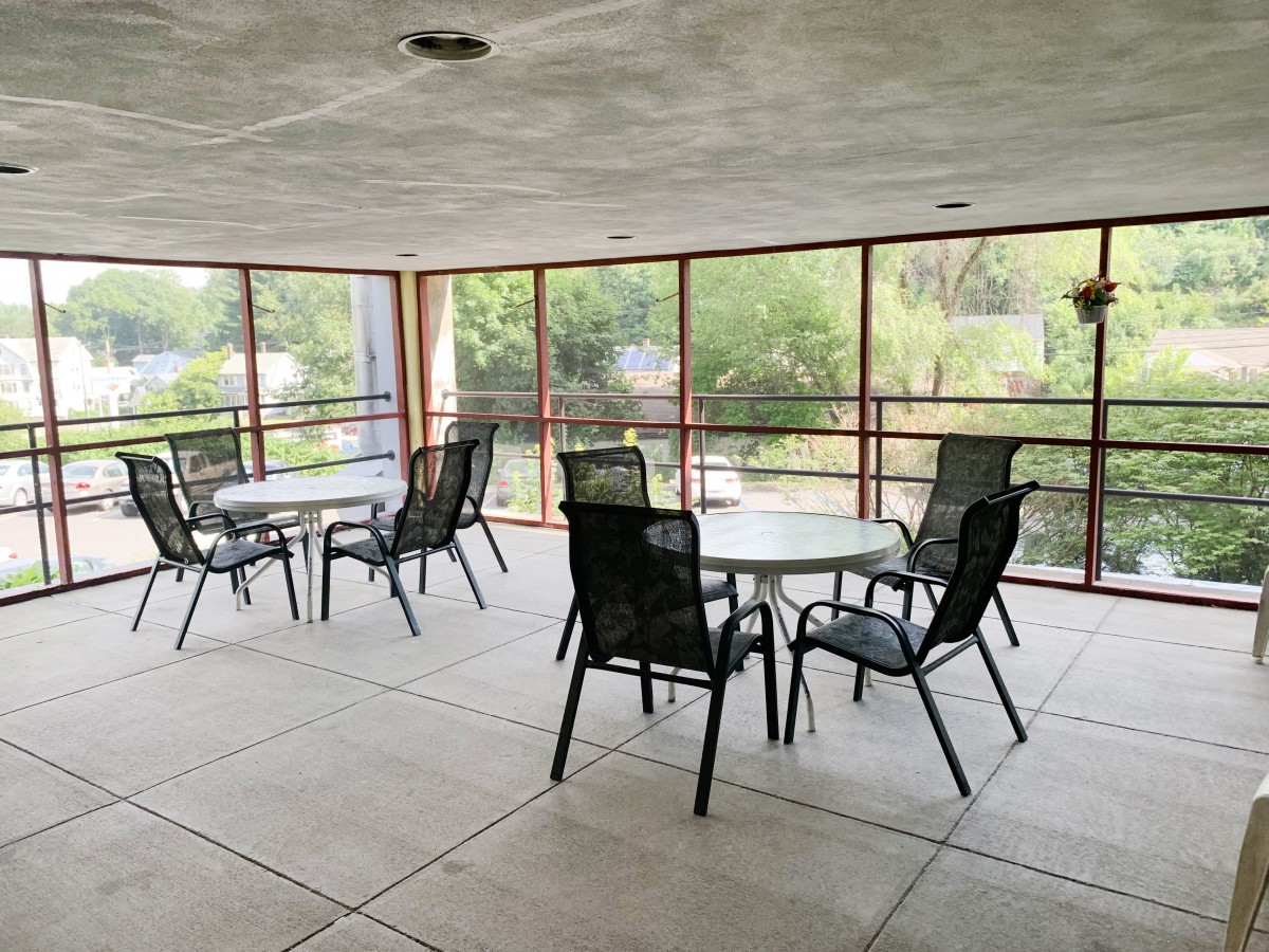 A screened patio area with tables and chairs arranged for outdoor seating.