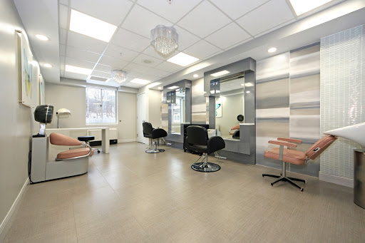 A modern and minimalist beauty salon interior featuring stylish chairs and large mirrors.
