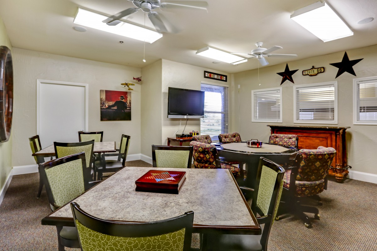 A modern living room with tables, chairs, and a television.
