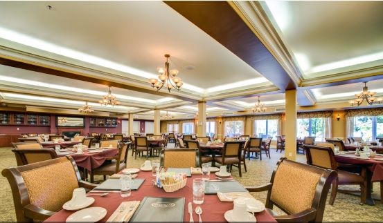 An elegant dining area with neatly arranged tables and chandeliers.
