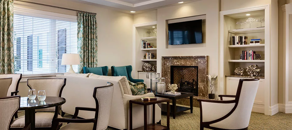 A cozy and elegantly designed living room with a fireplace, television, and comfortable seating.